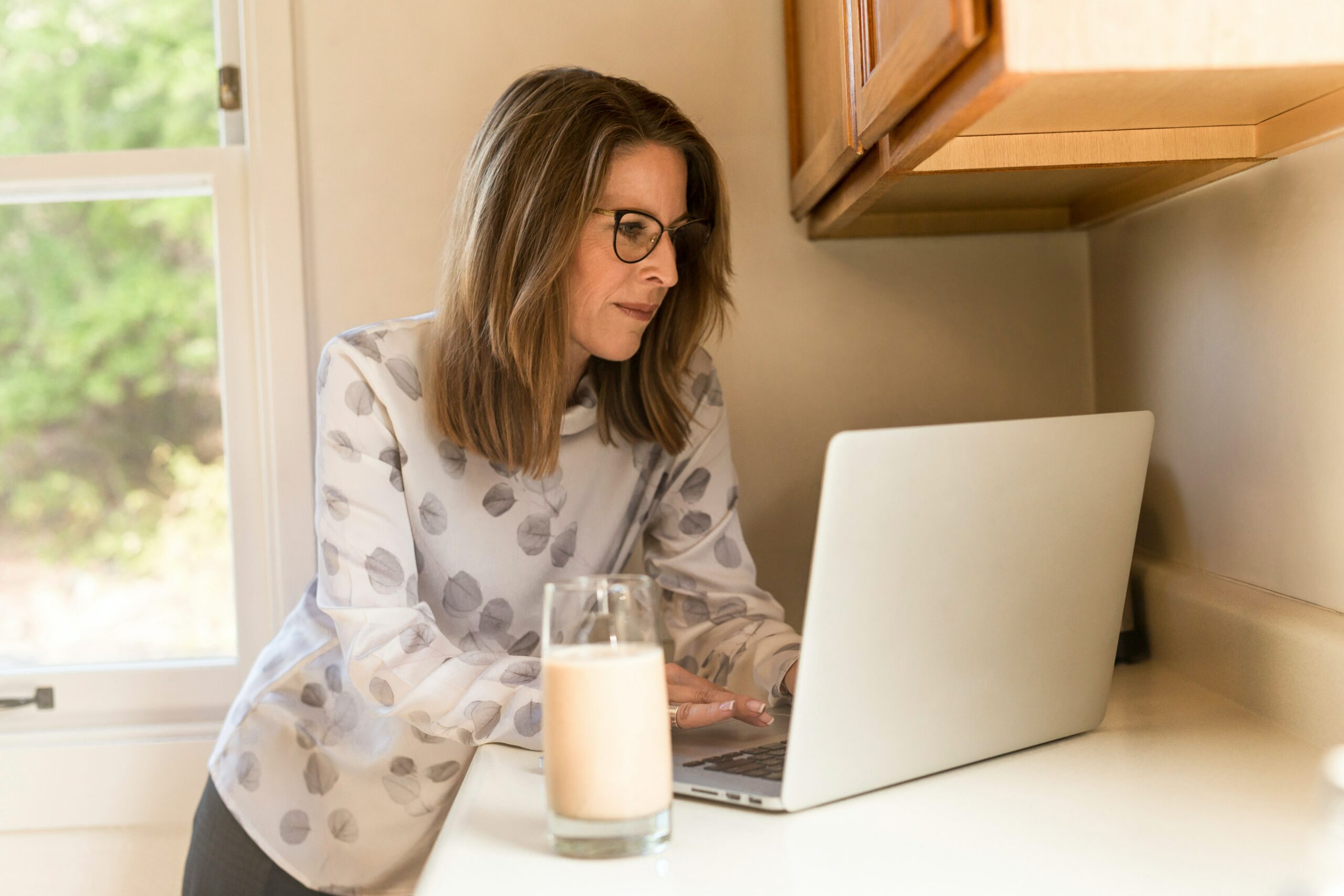 Woman reviewing real estate listings on laptop.