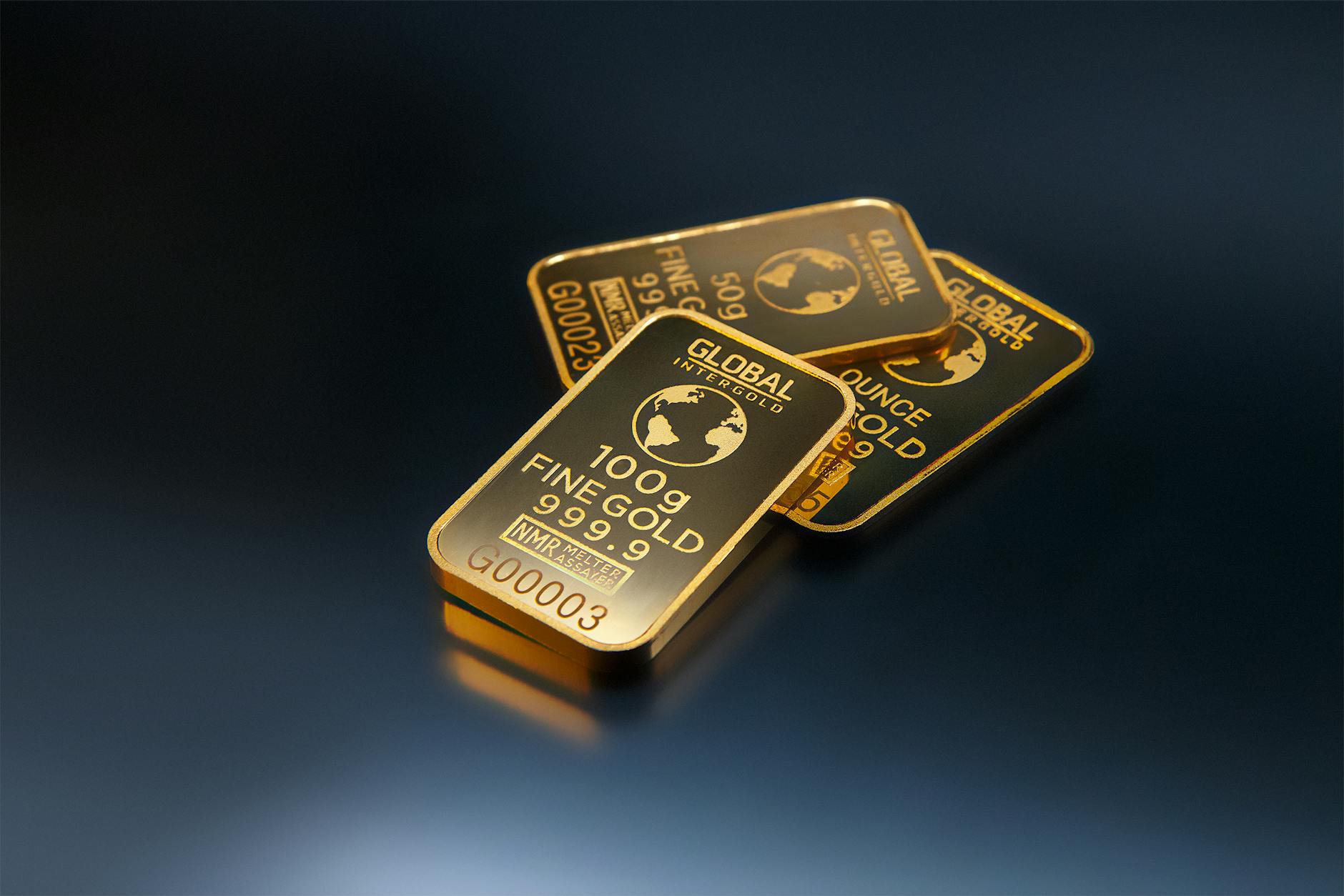 three gold bars against dark background